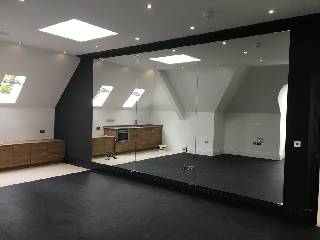 Frameless glass wall dividing loft conversion in Waltham Cross